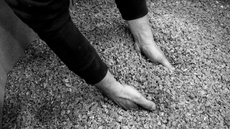 Imagen de manos sosteniendo granza de origen post-consumo